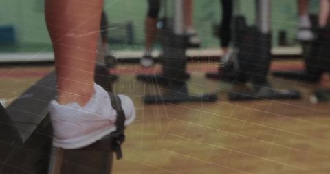 Close-up foot stepping on black aerobic step with white sneaker strap for group fitness