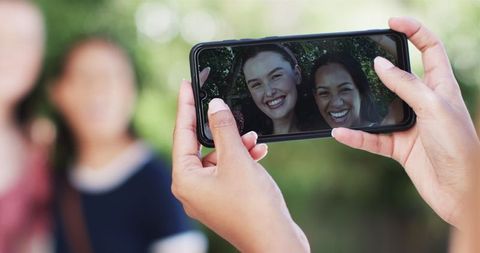 Woman Taking Photos of Happy Friends in Outdoor Setting