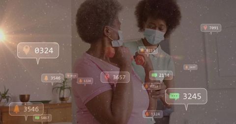 African american caregiver guiding senior during home arm-strengthening with digital alerts
