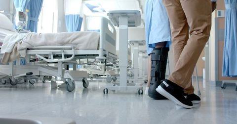 Doctor Assisting Patient with Leg Brace in Hospital Ward - Download Free Stock Images Pikwizard.com