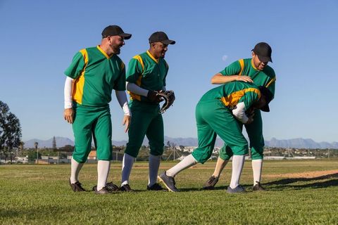 Baseball Teammates Supporting Hurt Player on Field Showing Camaraderie and Team Spirit