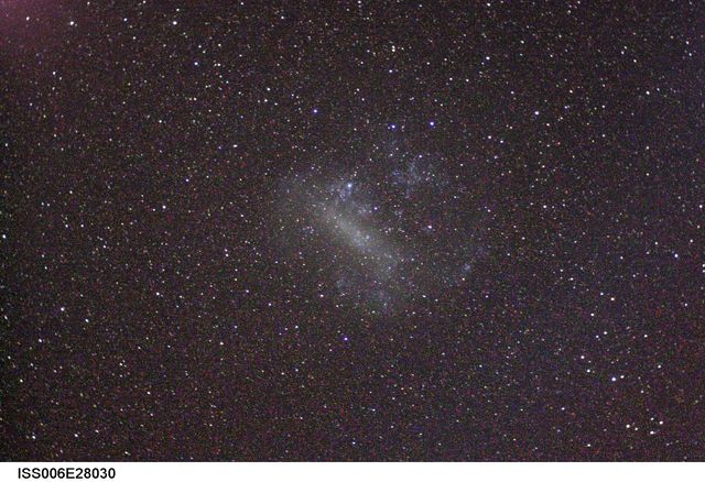 Astronaut captures vivid details of the Large Magellanic Cloud from the International Space Station in February 2003. This type of image can be used for educational materials, presentations on astronomy, space-themed publications, or as an inspirational piece for science enthusiasts.