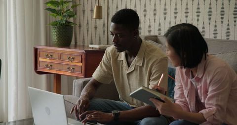 Interracial couple planning wedding together at home