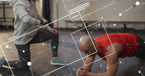 Trainer Checking Watch While Athlete Holding Forearm Plank During Core Stability Training