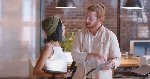 Colleagues collaborating with digital tablets in modern office