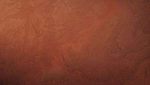 Displaying rusty cracked earth texture with winding fissures and warm terracotta tones