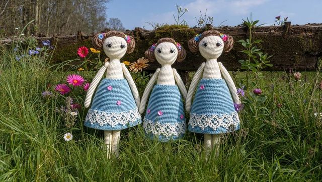 Handcrafted crochet dolls in rustic meadow with wildflowers