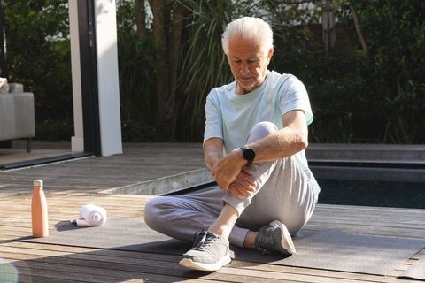 Senior man enjoying outdoor stretching by poolside