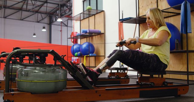 Determined Woman with Prosthetic Leg Using Rowing Machine at Gym - Download Free Stock Images Pikwizard.com