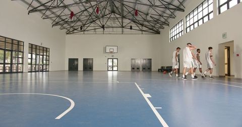 Basketball team practicing in spacious indoor court