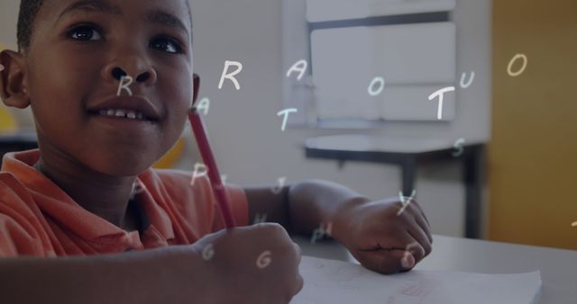 Young boy practicing writing the alphabet while seated at a school desk. Ideal for education materials, articles on early childhood education, and promoting literacy programs.