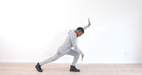 Young Man in Gray Tracksuit Practicing Dance Moves