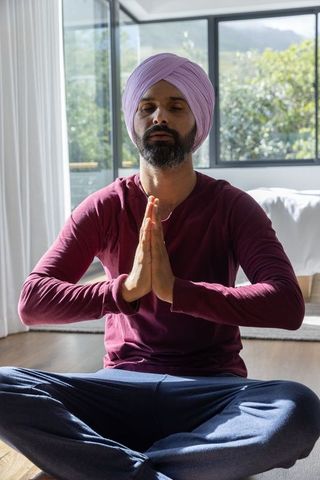 Indian Man Meditating in Bright Room Promoting Tranquility and Mindfulness