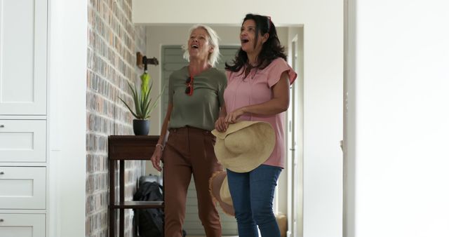 Excited Women in Casual Wear Embracing in Hallway - Download Free Stock Images Pikwizard.com