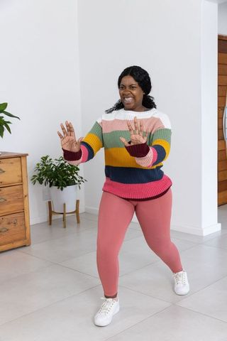 Woman in casual attire smiling and enjoying living space