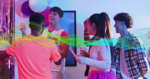 Friends laughing and dancing at neon home party with balloons and colorful lights