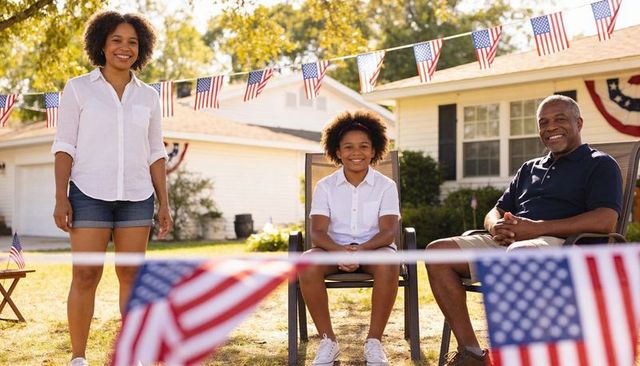 Multigenerational family celebrating fourth of july on front lawn with american flag bunting