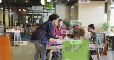 Team collaborating at table with digital notifications overlay for creative ideation