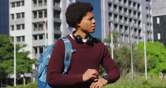 Young man checking watch outdoors with city buildings in background - Download Free Stock Images Pikwizard.com