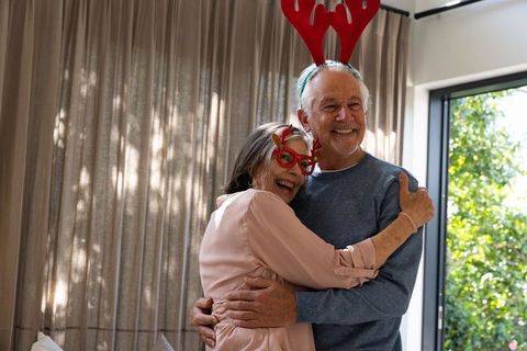 Senior Couple Celebrating with Reindeer Antlers and Joyful Embrace