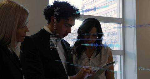 Business team reviewing data on tablet with holographic interface and code overlays