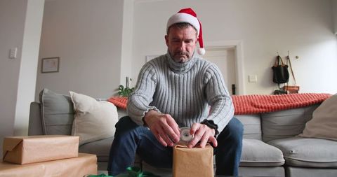 Man in santa hat splash of holiday cheer at home