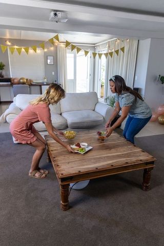 Women Arranging Snacks for Festive Gathering at Home