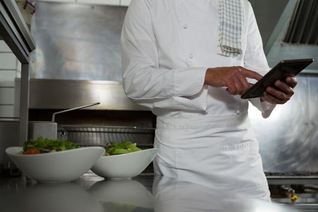 Male chef using mobile phone in the kitchen - Download Free Stock Photos Pikwizard.com