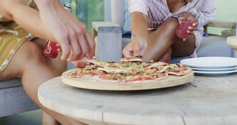 Friends Sharing Homemade Pizza at Outdoor Gathering