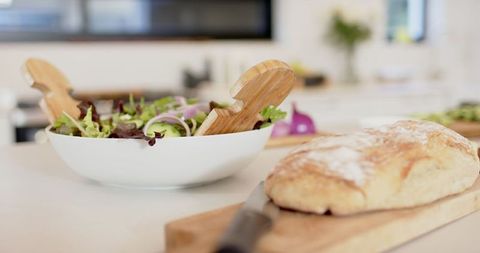 Fresh salad and rustic bread on kitchen counter