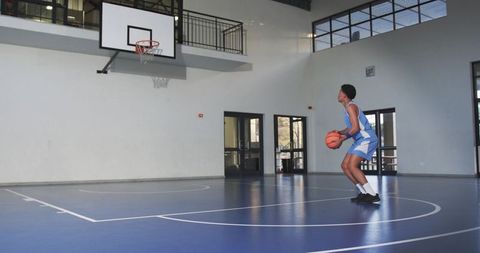 Young basketball player focused on shooting practice indoors