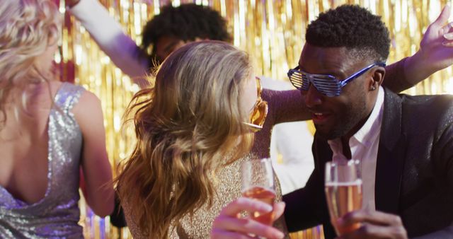 Image of two happy diverse couples dancing holding glasses of champagne at a nightclub. Fun, drinking, going out and party concept.