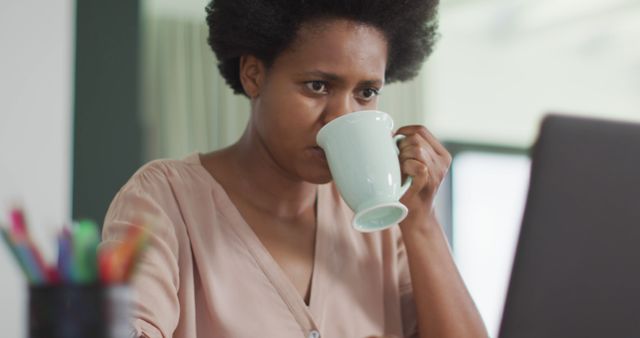 Businesswoman Drinking Coffee While Working on Laptop in Home Office - Download Free Stock Images Pikwizard.com