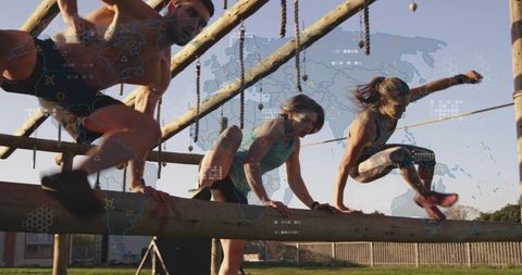 Athletes balancing and vaulting over wooden beam on outdoor obstacle course in sunlight