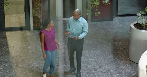 Team building in office corridor woman and businessman collaborating