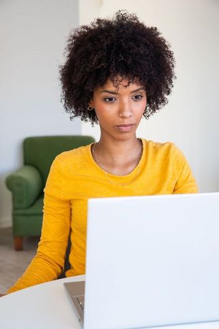 Focused Businesswoman Using Laptop in Home Office