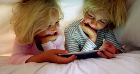 Children Enjoying Digital Tablet Under Blanket Fort