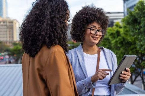 African american coworkers collaborating on tablet rooftop city skyline business meeting
