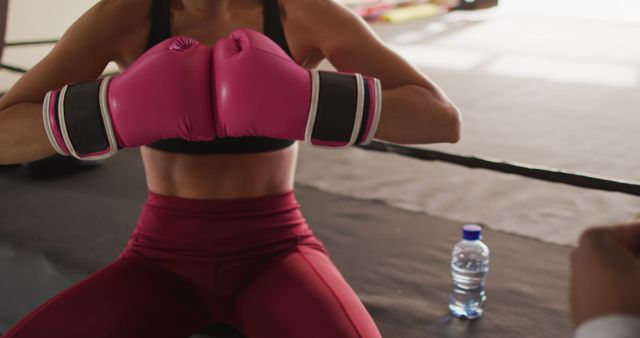 Image of midsection of fit caucasian woman preparing for box training at gym. active, fit, sporty and healthy lifestyle, exercising at gym concept.