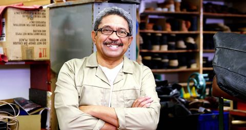 Cobbler Smiling with Crossed Arms in Shoe Repair Workshop - Download Free Stock Images Pikwizard.com