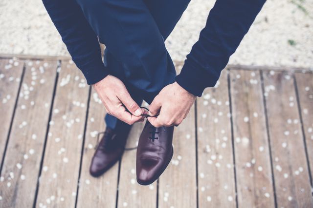 Businessman Tying Shoelaces on Wooden Deck Outdoors - Download Free Stock Photos Pikwizard.com