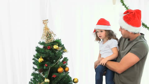 Father and Daughter Decorating a Christmas Tree Together