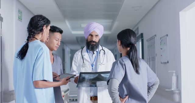 Diverse Medical Team Discussing Patient X-Ray in Hospital Corridor - Download Free Stock Images Pikwizard.com