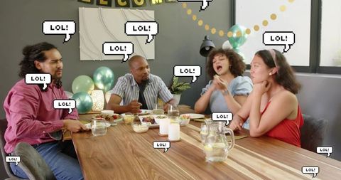 Diverse friends laughing and sharing feast at wooden table during home celebration