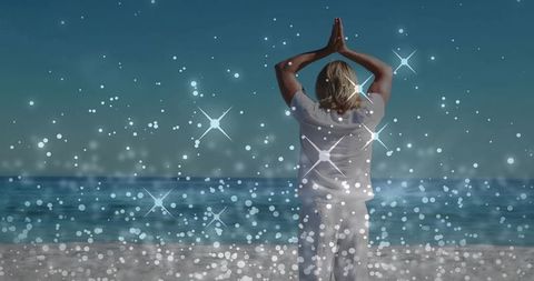 Man Practicing Namaste Yoga on Serene Beach with Sparkling Bokeh and Ocean Horizon