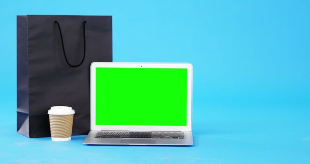 Laptop with green screen alongside coffee cup and shopping bag - Download Free Stock Images Pikwizard.com