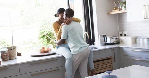 Diverse Couple Sharing Intimate Moment in Modern Kitchen