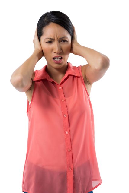 Young woman in red blouse covering her ears, expressing frustration and annoyance. Isolated on white background. Useful for concepts related to stress, noise pollution, emotional reactions, and mental health awareness.