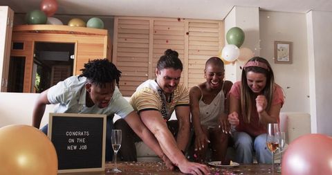Friends celebrating new job with confetti and drinks