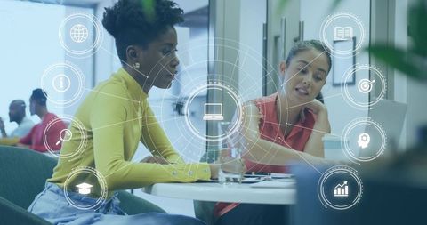 Colleagues collaborating over laptop with holographic ui overlay in modern office